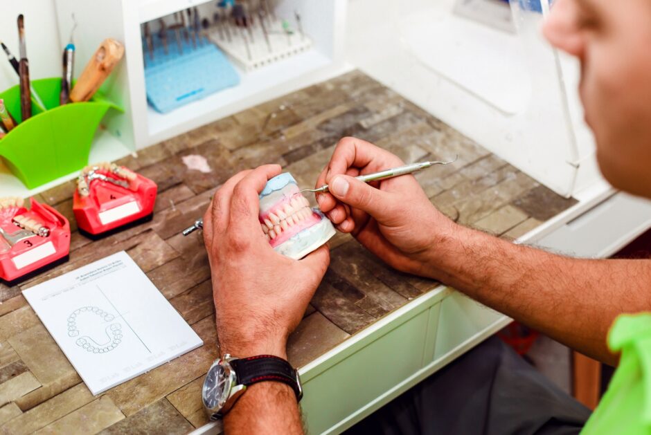 Dentist preparing artificial teeth with a special tool