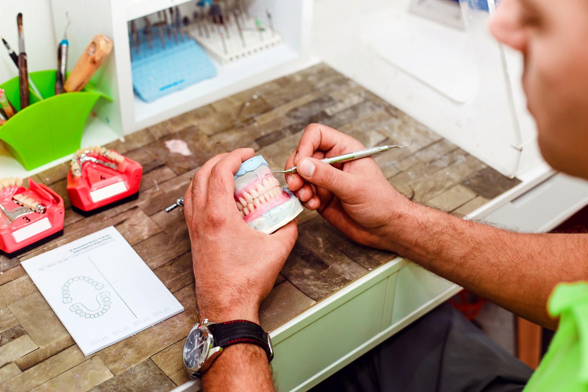 Dentist preparing artificial teeth with a special tool
